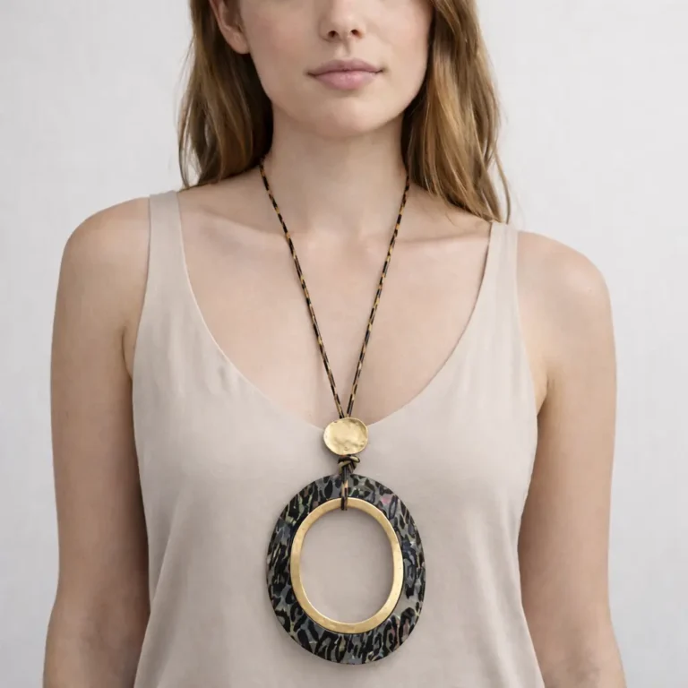 mujer luce un Collar largo con colgante ovalado animal print y aro dorado grande.